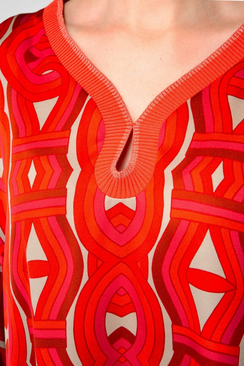 IVI collection GRACE elegante Seidentunika mit Cut-Out-Detail am V-Ausschnitt mit graphischen Print in leuchtenden Rot-Farben aus der AW24 Kollektion.

IVI collection GRACE elegant silk tunic with cut-out detail at the V-neckline with graphic print in bright red colors from the AW24 collection.