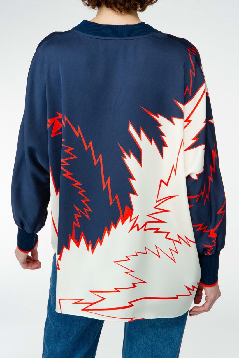 IVI collection FLASH Seidentunika mit auffälligem Grafik-Print in den Farben weiß und blau und roten Akzenten aus der AW24 Kollektion.

IVI collection FLASH silk tunic with an eye-catching graphic print in white and blue with red accents from the AW24 collection.