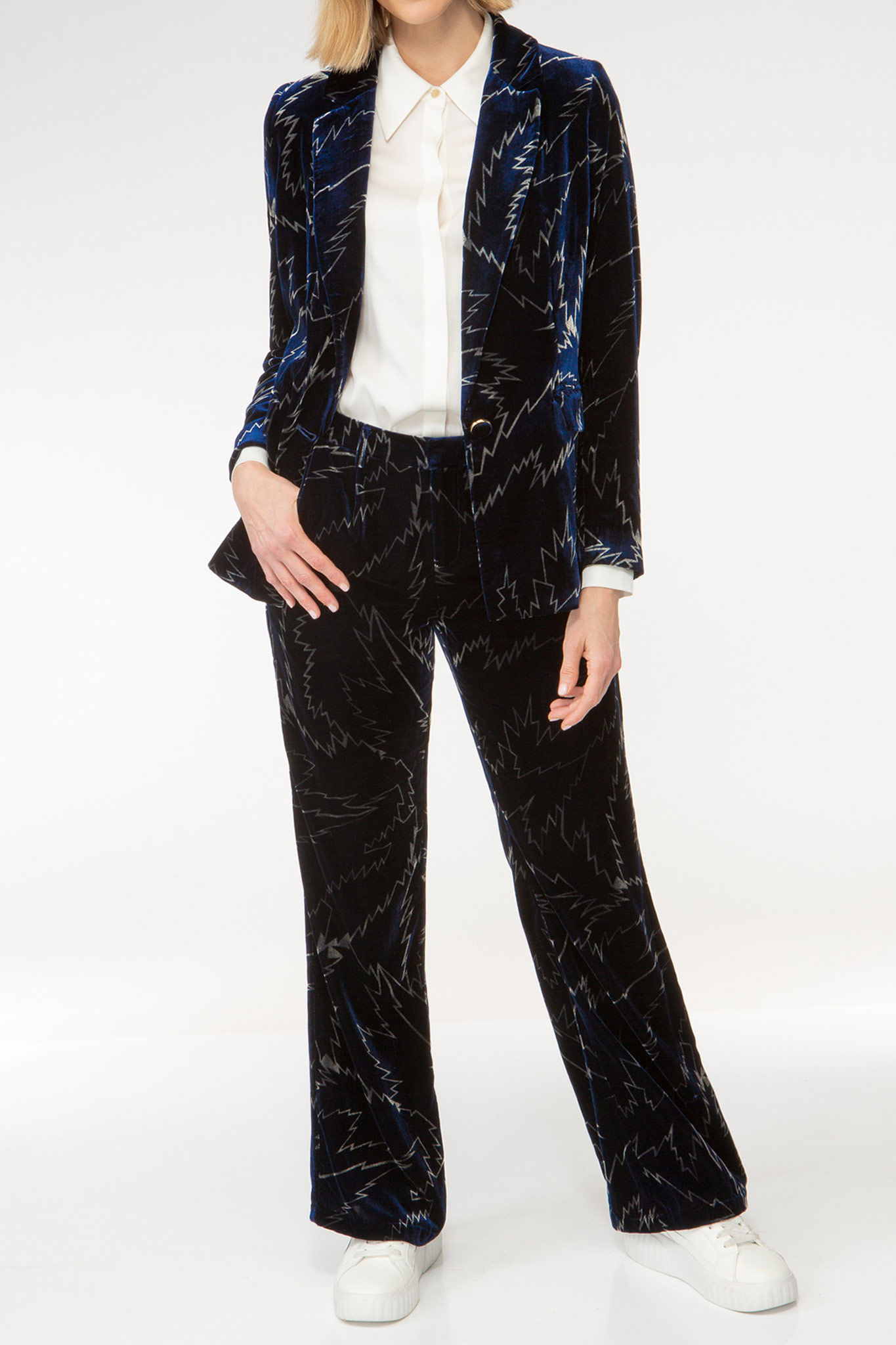 IVI collection FLASH bedruckte Hose mit Bundfalten und weitem Bein in leichter Bootcut Silhouette aus weichem Samtstoff mit auffälligem Grafik-Print in den Farben silber und blau aus der AW24 Kollektion. IVI collection FLASH printed trousers with pleats and a wide leg in a slight bootcut silhouette made of soft velvet fabric with an eye-catching graphic print in silver and blue from the AW24 collection.