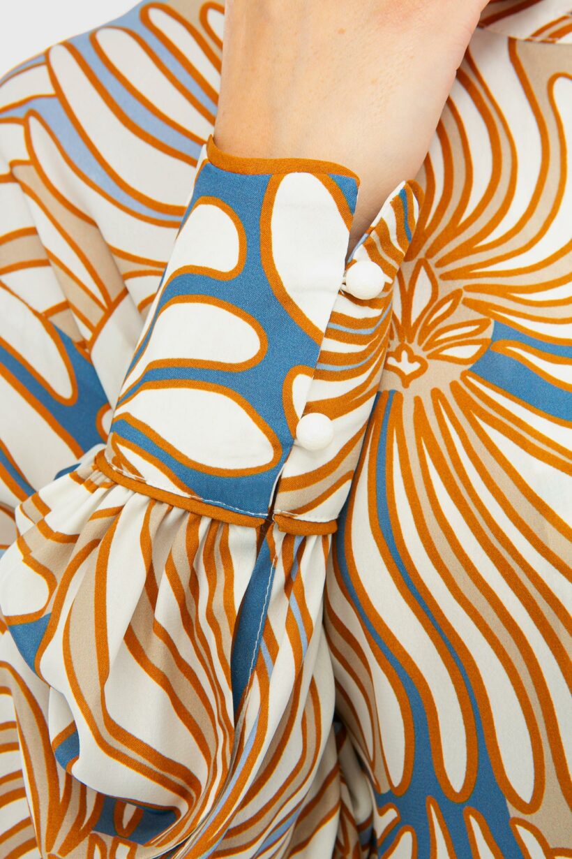 IVI collection SWIRL hochwertige Seidenbluse in den Farben hellblau und beige aus der Resort25 Kollektion.

IVI collection SWIRL high-quality silk blouse in the colors light blue and beige from the Resort25 collection.
