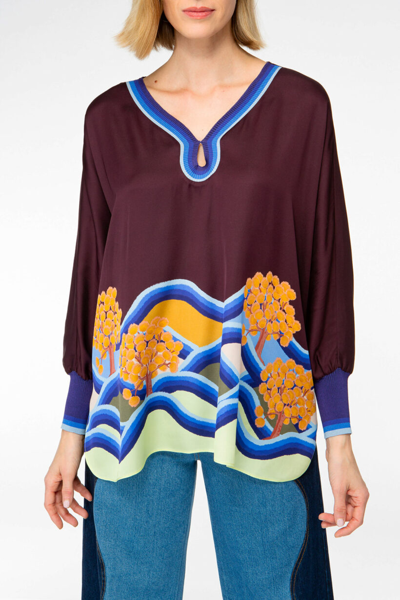 IVI collection PARADISE WAVE elegante Seidentunika mit Cut-Out-Detail am V-Ausschnitt mit Natur-Print in lila aus der AW24 Kollektion. IVI collection PARADISE WAVE elegant silk tunic with cut-out detail at the V-neckline with natural print in purple from the AW24 collection.