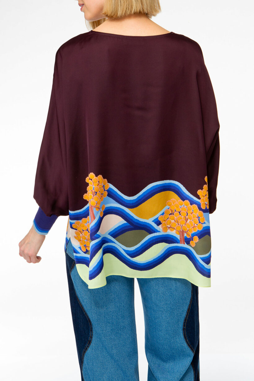 IVI collection PARADISE WAVE elegante Seidentunika mit Cut-Out-Detail am V-Ausschnitt mit Natur-Print in lila aus der AW24 Kollektion. IVI collection PARADISE WAVE elegant silk tunic with cut-out detail at the V-neckline with natural print in purple from the AW24 collection.