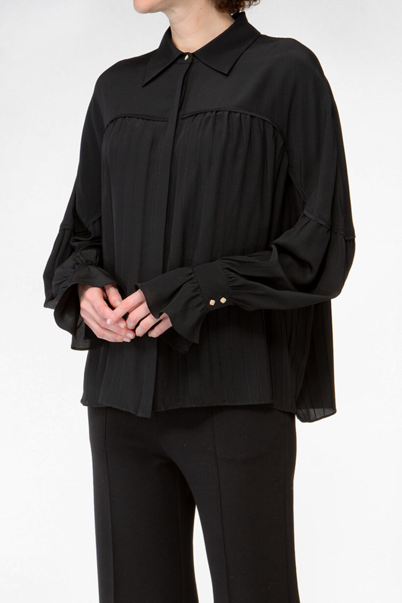 IVI collection black blouse with pleat detail in the font and back with a golden button at the top made from 100% silk from aw24 collection
