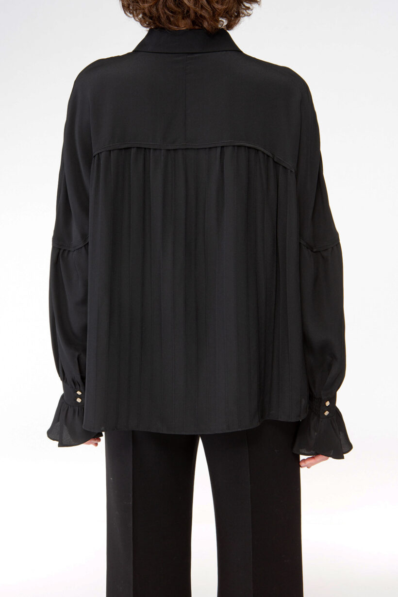 IVI collection black blouse with pleat detail in the font and back with a golden button at the top made from 100% silk from aw24 collection