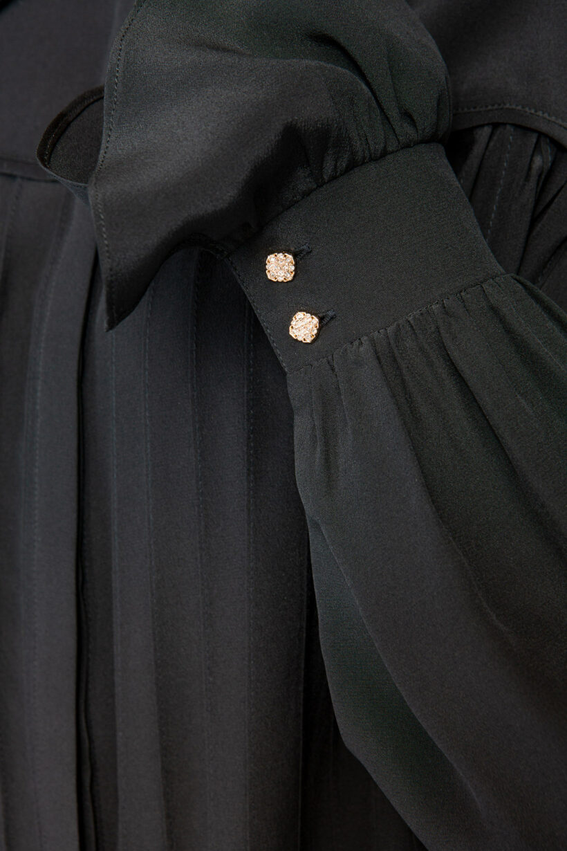 IVI collection black blouse with pleat detail in the font and back with a golden button at the top made from 100% silk from aw24 collection