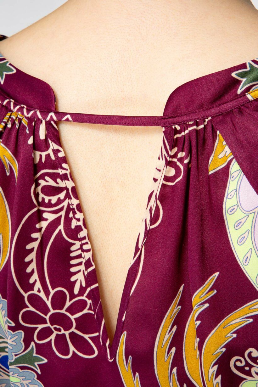 IVI collection GLAMOROUS Seidenbluse mit Cut-Out und floralem Print in in gelb und blau auf bordeaux aus der AW24 Kollektion. IVI collection GLAMOROUS silk blouse with cut-out and floral print in yellow and blue on bordeaux from the AW24 collection.